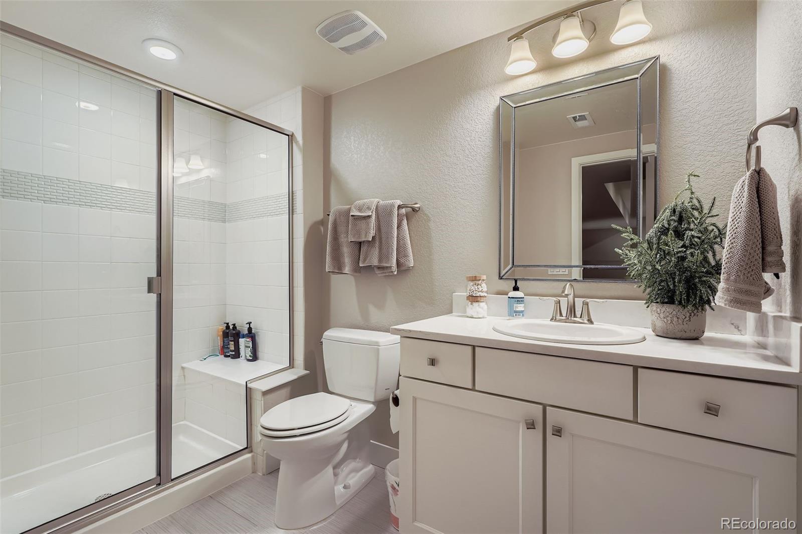 10414 Maplebrook Way Highlands Ranch, CO 80126 - Photo 30 of 45 a bathroom with a toilet a sink a tub and mirror