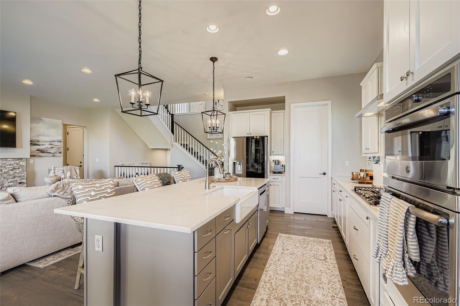 10414 Maplebrook Way Highlands Ranch, CO 80126 - Photo 3 of 45 a large kitchen with stainless steel appliances kitchen island granite countertop a sink a stove and a refrigerator