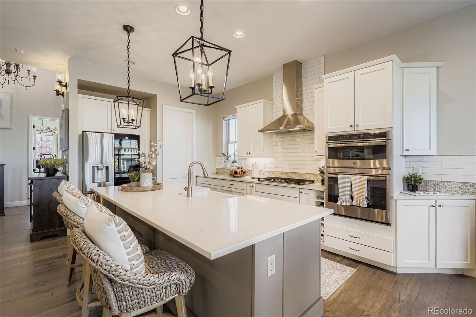 10414 Maplebrook Way Highlands Ranch, CO 80126 - Photo 5 of 45 a kitchen with stainless steel appliances granite countertop a sink a stove and a wooden floors