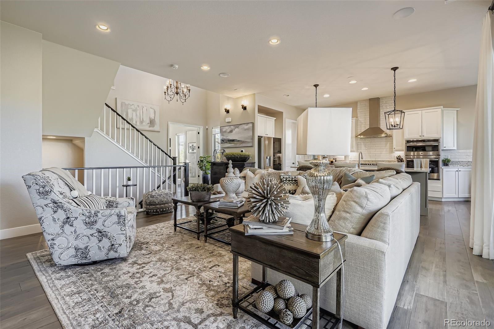 10414 Maplebrook Way Highlands Ranch, CO 80126 - Photo 9 of 45 a living room with furniture kitchen view and a chandelier