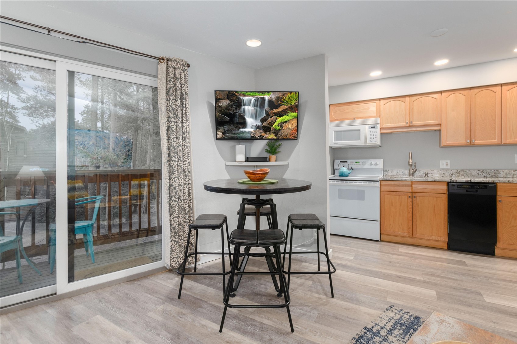 1140 Ski Hill Road, Unit 27 Breckenridge, CO 80424 - Photo 7 of 26 a kitchen with stainless steel appliances kitchen island a table chairs in it and wooden floors
