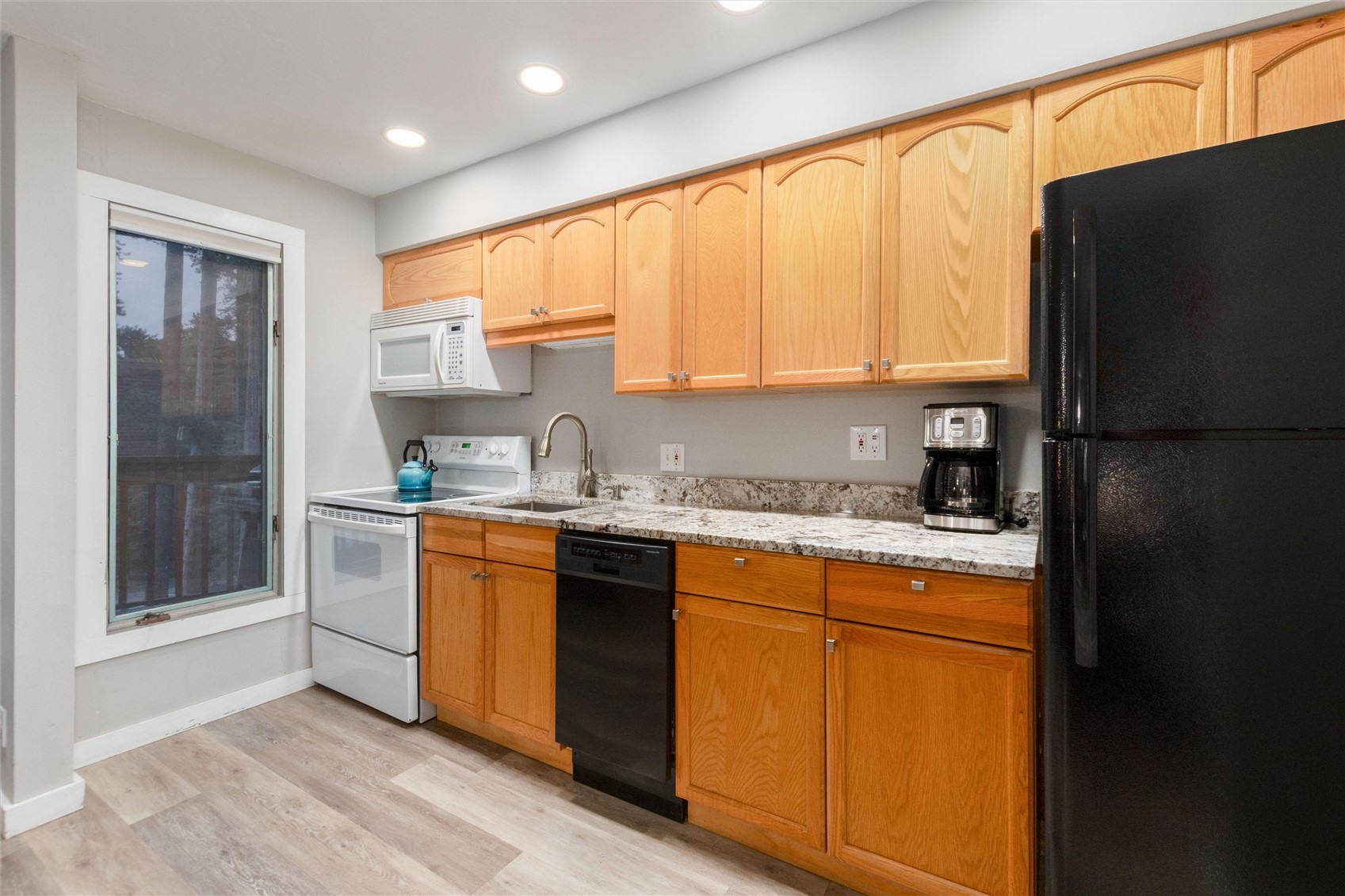 1140 Ski Hill Road, Unit 27 Breckenridge, CO 80424 - Photo 9 of 26 a kitchen with stainless steel appliances granite countertop a refrigerator a sink dishwasher a stove and a refrigerator with wooden floor