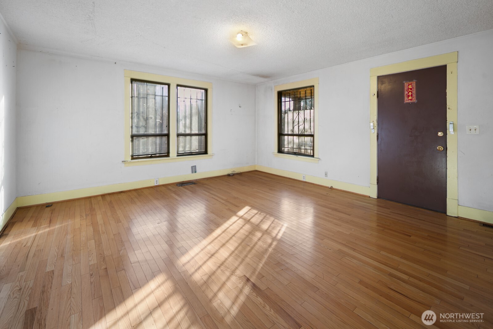 3226 South Edmunds Street Seattle, WA 98118 - Photo 7 of 35 a view of an empty room with wooden floor and a window