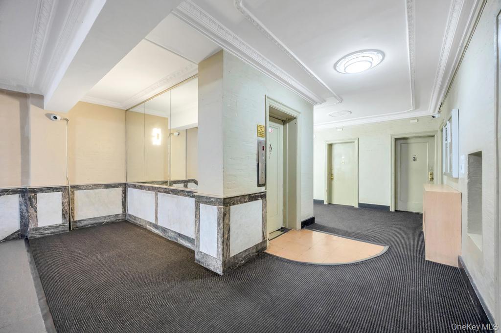 83-64 Talbot Street, Unit 3A Queens, NY 11415 - Photo 11 of 15 Building common area featuring patterned carpet flooring and a decorative ceiling with crown molding