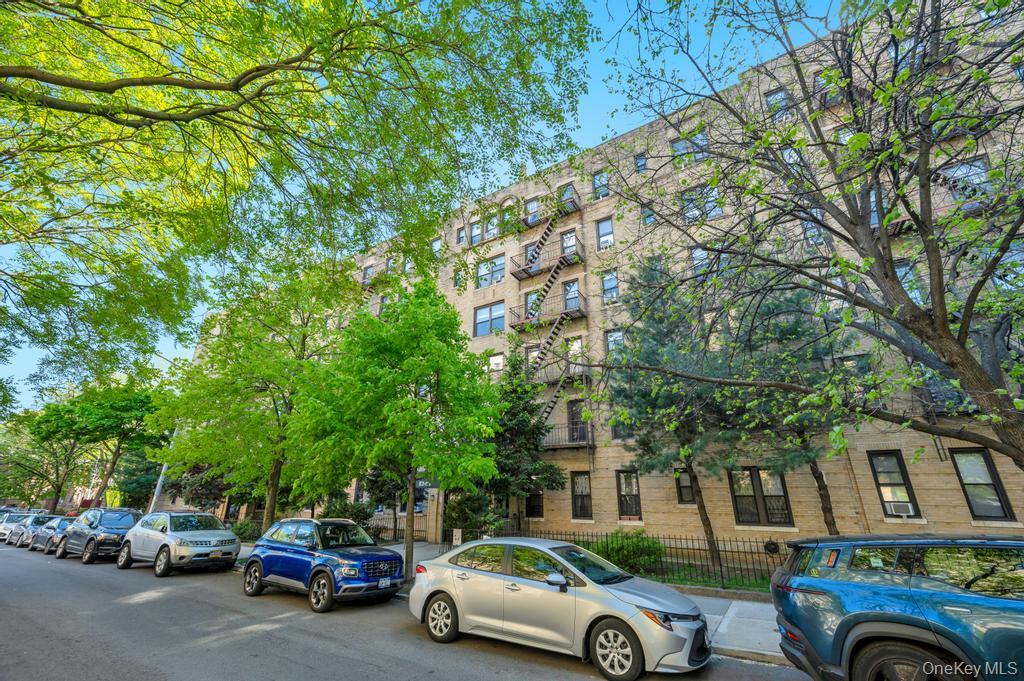 83-64 Talbot Street, Unit 3A Queens, NY 11415 - Photo 13 of 15 Multi-story building featuring a light-colored brick exterior and dark-framed windows