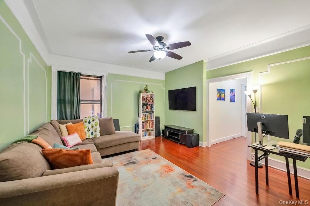 83-64 Talbot Street, Unit 3A Queens, NY 11415 - Photo 2 of 15 Living area featuring wood-finish flooring, a ceiling fan, and decorative wall molding