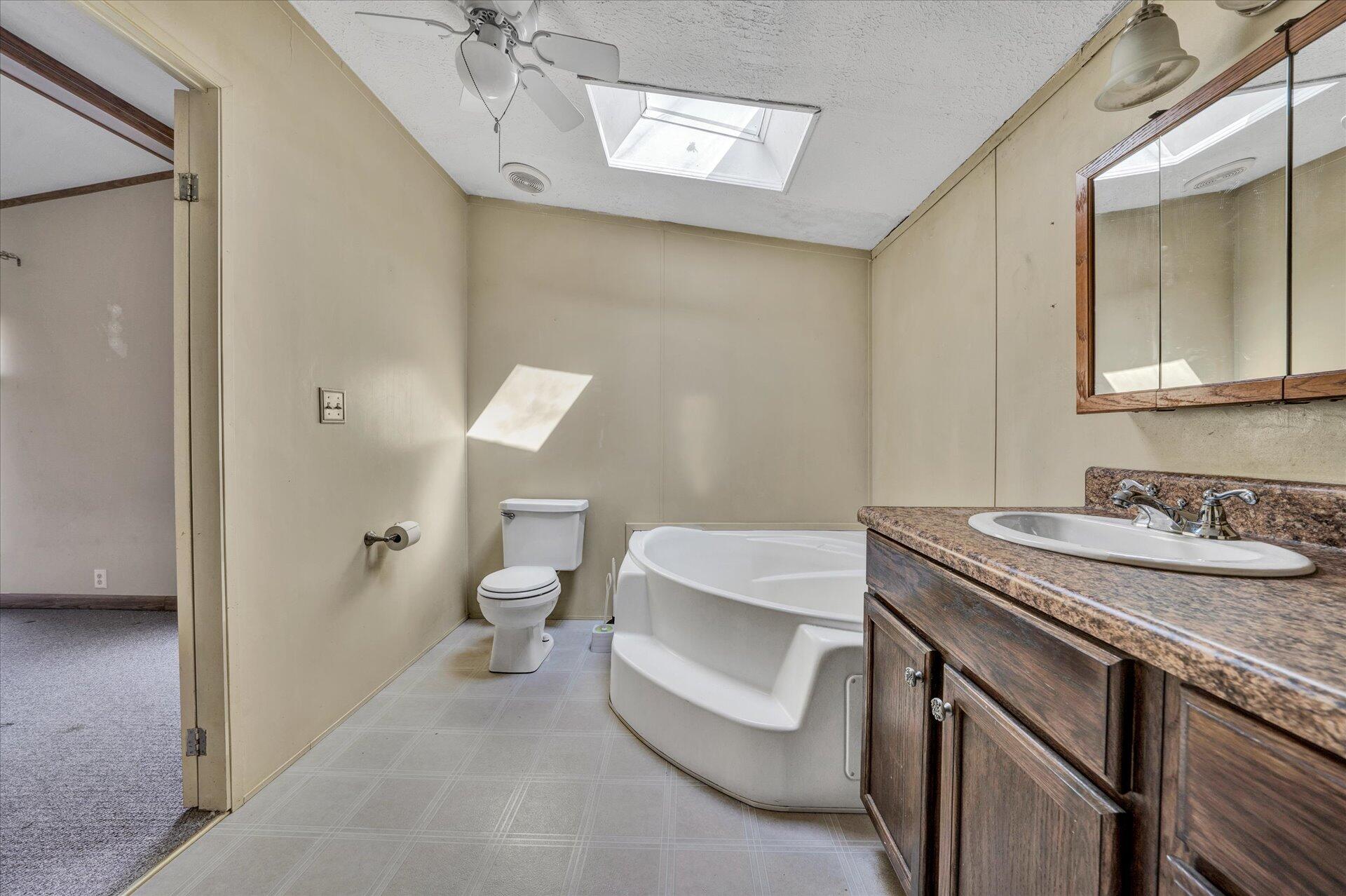 2121 Cannady School Road Southeast Floyd, VA 24091 - Photo 15 of 41 a bathroom with a granite countertop sink a toilet and a mirror