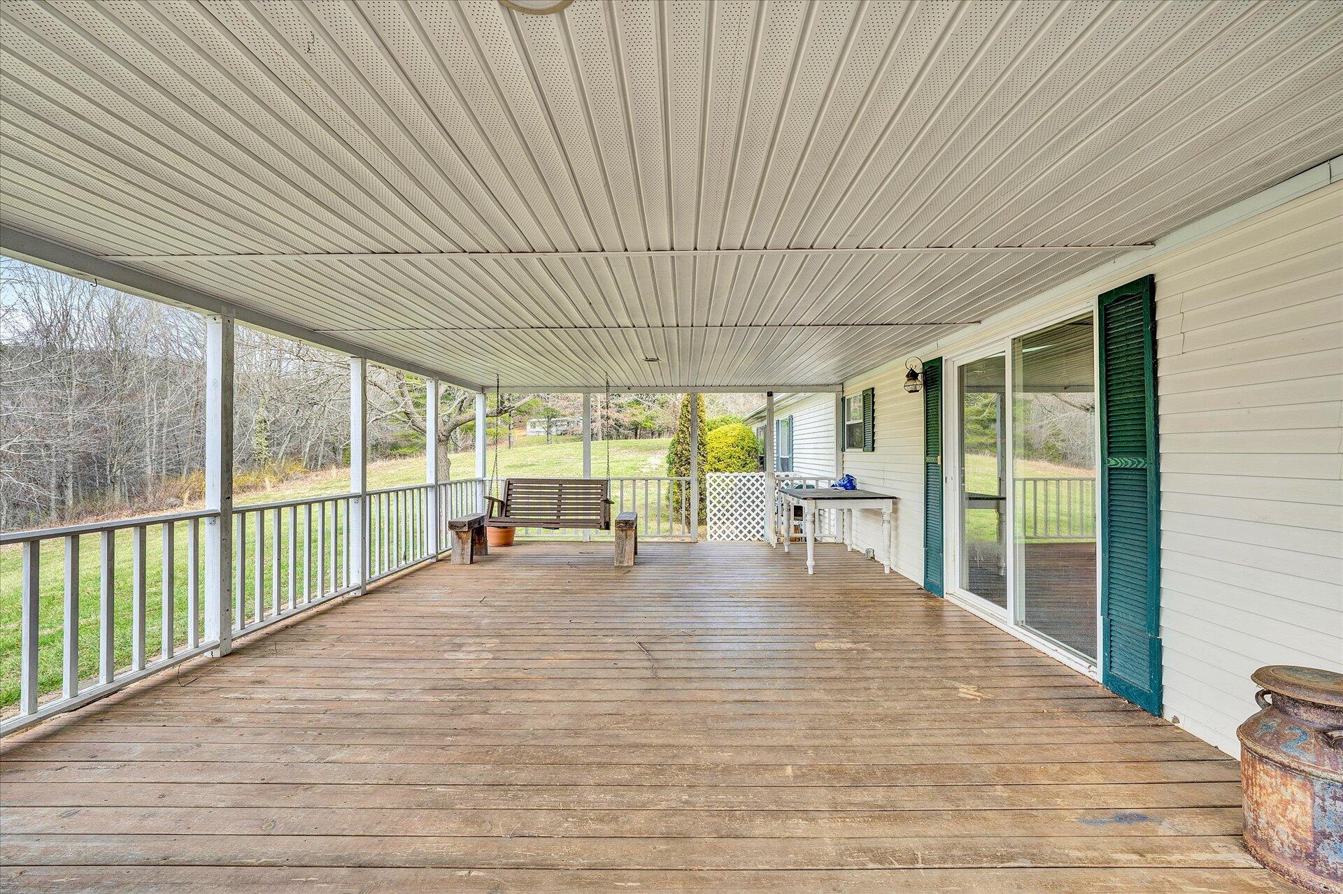 2121 Cannady School Road Southeast Floyd, VA 24091 - Photo 21 of 41 a view of a patio with table and chairs next to a yard with wooden roof