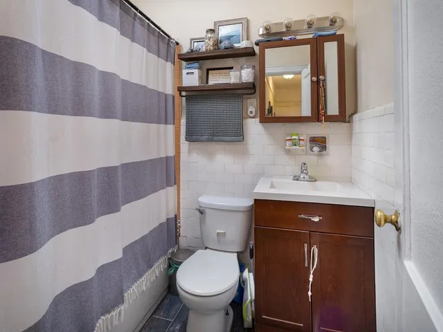 a bathroom with a toilet a sink and mirror