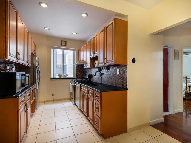 a kitchen with stainless steel appliances granite countertop a stove a sink and a microwave