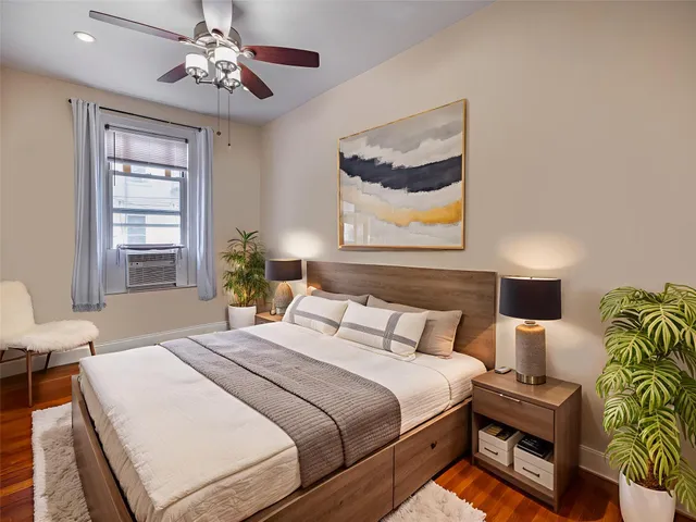 a bedroom with a bed a chandelier and dresser