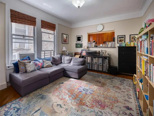 a living room with furniture a flat screen tv and a window