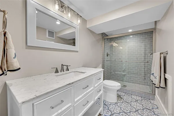 a bathroom with a granite countertop sink toilet and shower