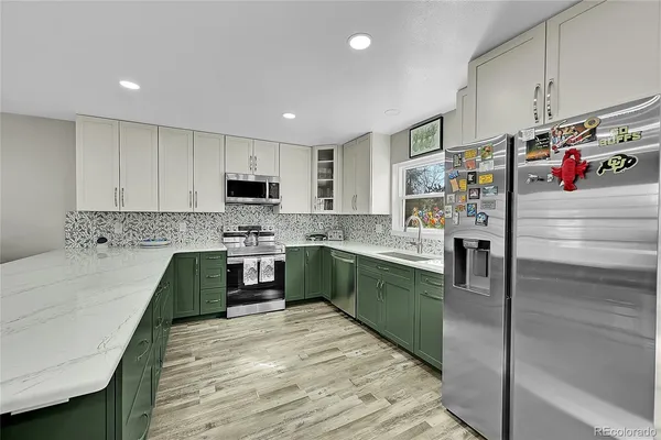 a kitchen with stainless steel appliances granite countertop a refrigerator sink and stove