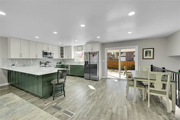 a kitchen with a dining table chairs refrigerator and cabinets