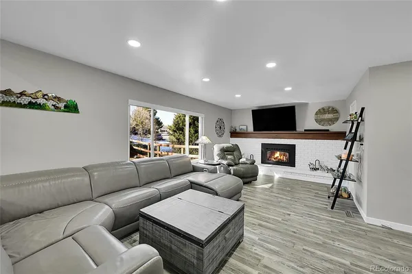 a living room with furniture a fireplace and a flat screen tv