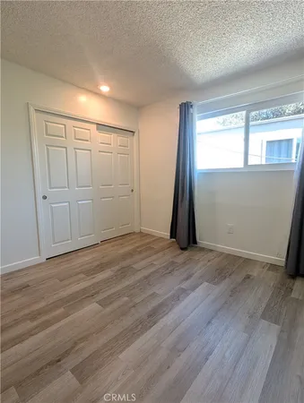 an empty room with wooden floor and closet
