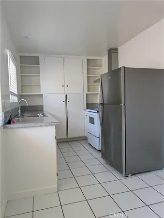 a kitchen with a refrigerator and a stove top oven