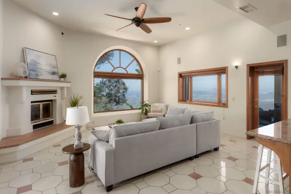 a living room with furniture a fireplace and a large window with garden view