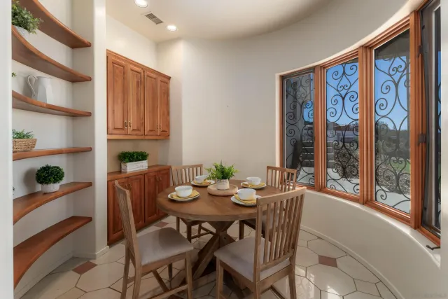 an empty room with wooden floor a ceiling fan a fireplace and windows