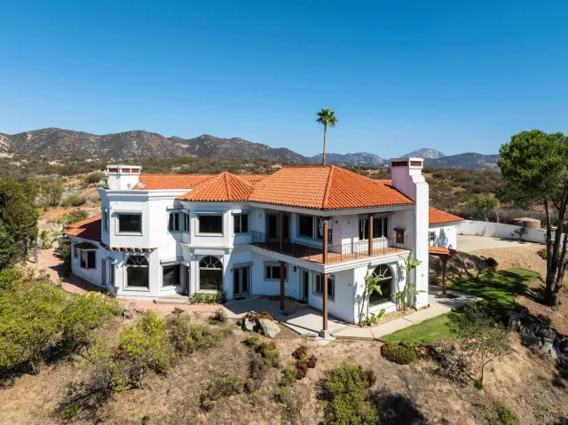 a view of a big house with a big yard and large tree