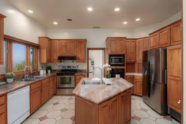 a kitchen with stainless steel appliances granite countertop a sink refrigerator and microwave