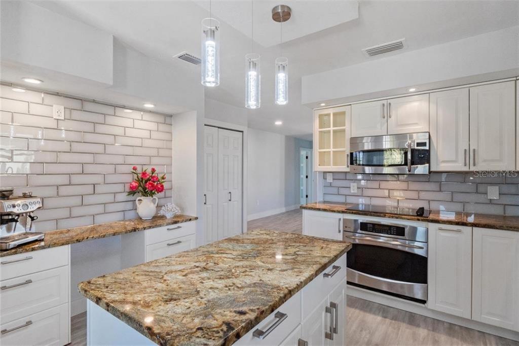 307 161st Avenue Redington Beach, FL 33708 - Photo 20 of 41 a kitchen with stainless steel appliances granite countertop a sink stove and cabinets