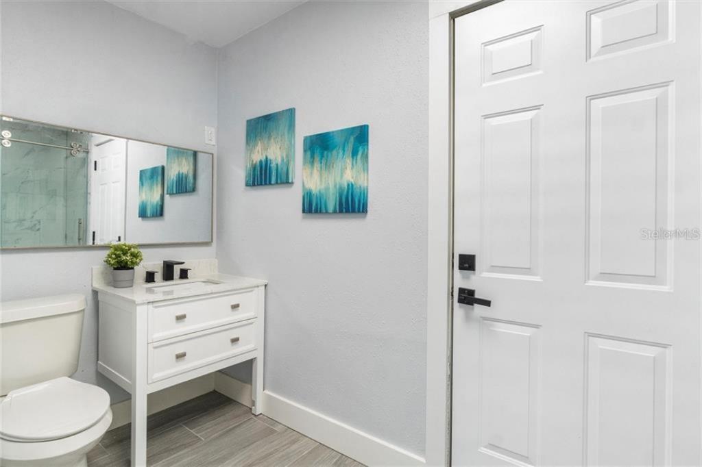 307 161st Avenue Redington Beach, FL 33708 - Photo 10 of 41 a bathroom with a toilet a sink a vanity and mirror