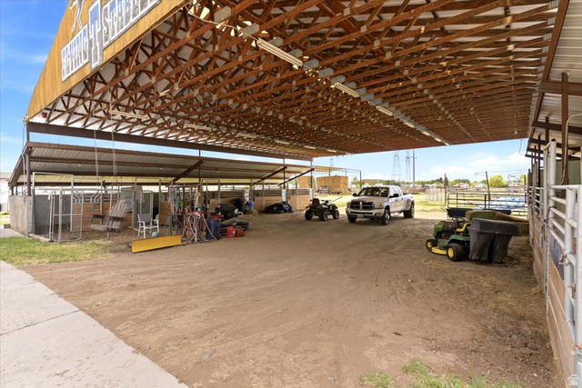 5321 South 3100th Street West Roy, UT 84067 - Photo 64 of 64 Spacious covered outdoor structure featuring a metal roof with exposed wood trusses, concrete flooring, and metal fencing
