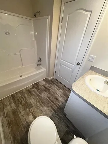 a bathroom with a granite countertop sink mirror vanity and toilet