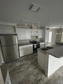 a kitchen with stainless steel appliances granite countertop a sink and a refrigerator
