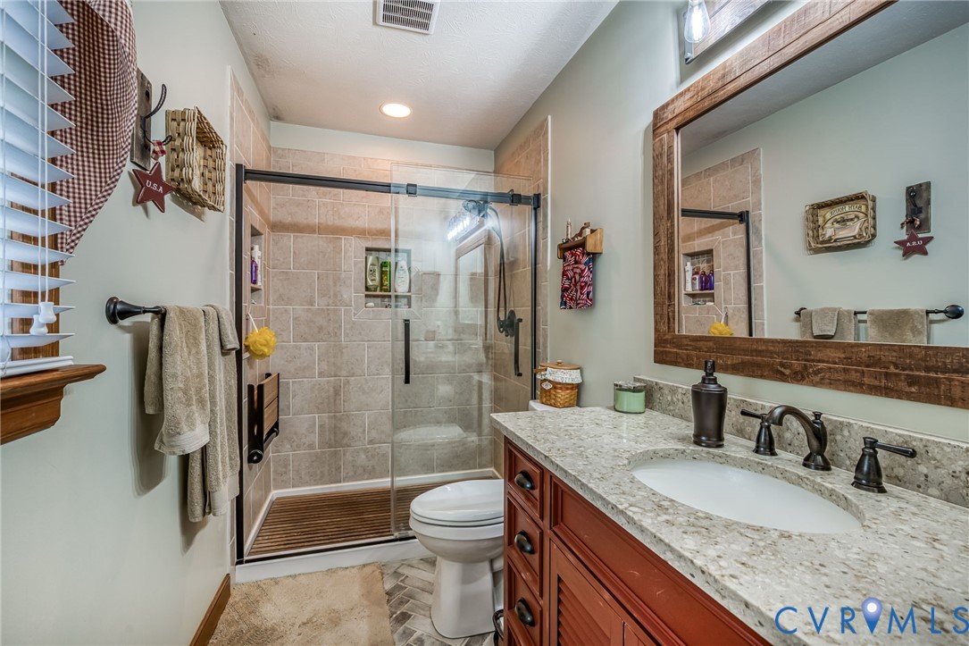 2081 Mill Road Henrico, VA 23231 - Photo 19 of 30 a bathroom with a granite countertop sink toilet and shower