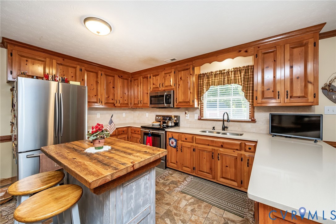 2081 Mill Road Henrico, VA 23231 - Photo 8 of 30 a kitchen with stainless steel appliances a stove refrigerator sink and cabinets