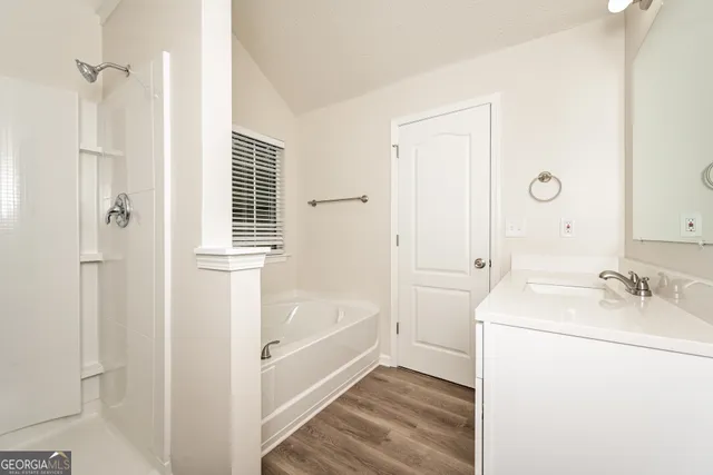 a bathroom with a tub sink and mirror