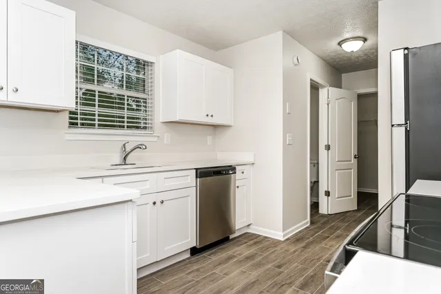 a kitchen with stainless steel appliances sink refrigerator and cabinets
