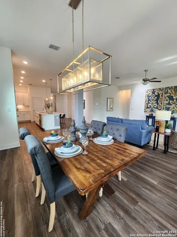 a view of a dining room and livingroom with furniture wooden floor a chandelier