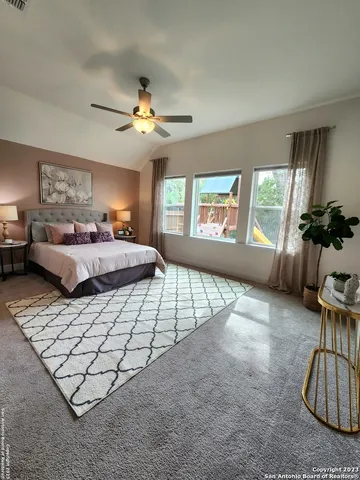 a bedroom with a bed and a lamp on dresser