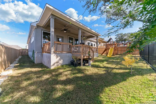 a view of an house with backyard and a tree