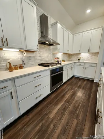 a kitchen with granite countertop white cabinets and white appliances