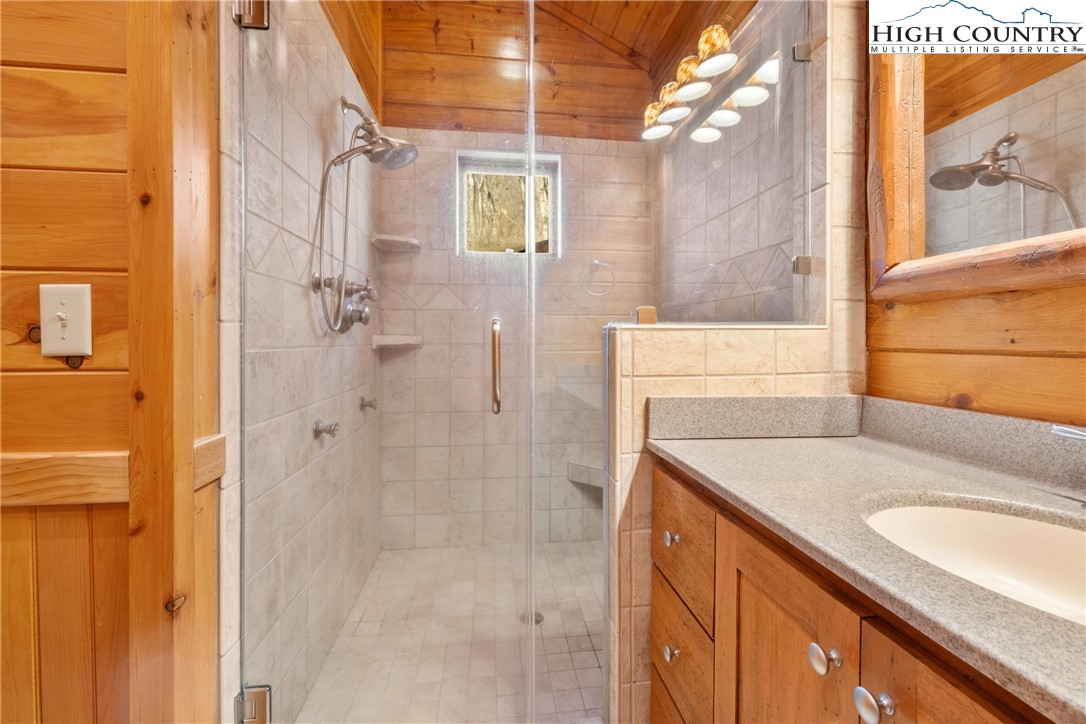 217 Rainbow Ridge Road Zionville, NC 28698 - Photo 26 of 46 a bathroom with a granite countertop sink a mirror and shower