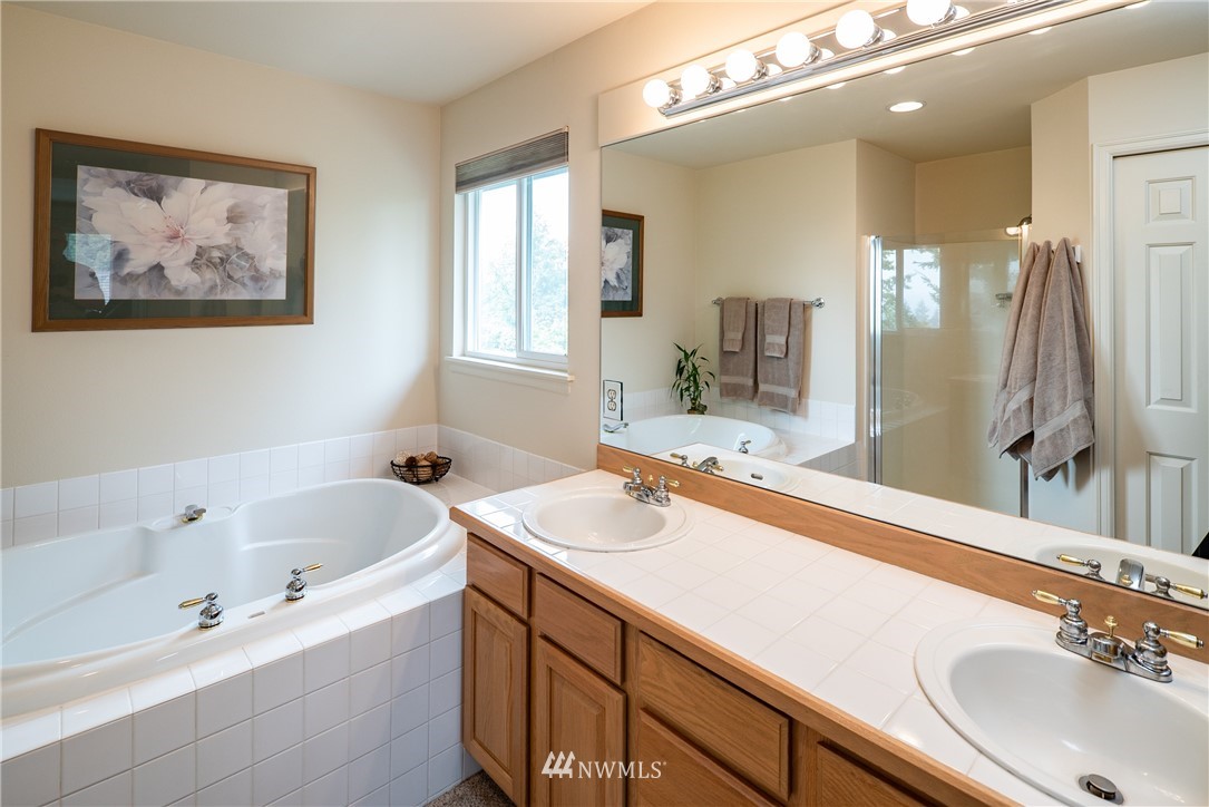 2825 202nd Street Southeast Bothell, WA 98012 - Photo 14 of 24 a bathroom with a tub a sink and mirror