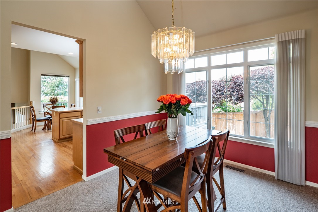 2825 202nd Street Southeast Bothell, WA 98012 - Photo 5 of 24 a view of a dining room with furniture a chandelier and wooden floor