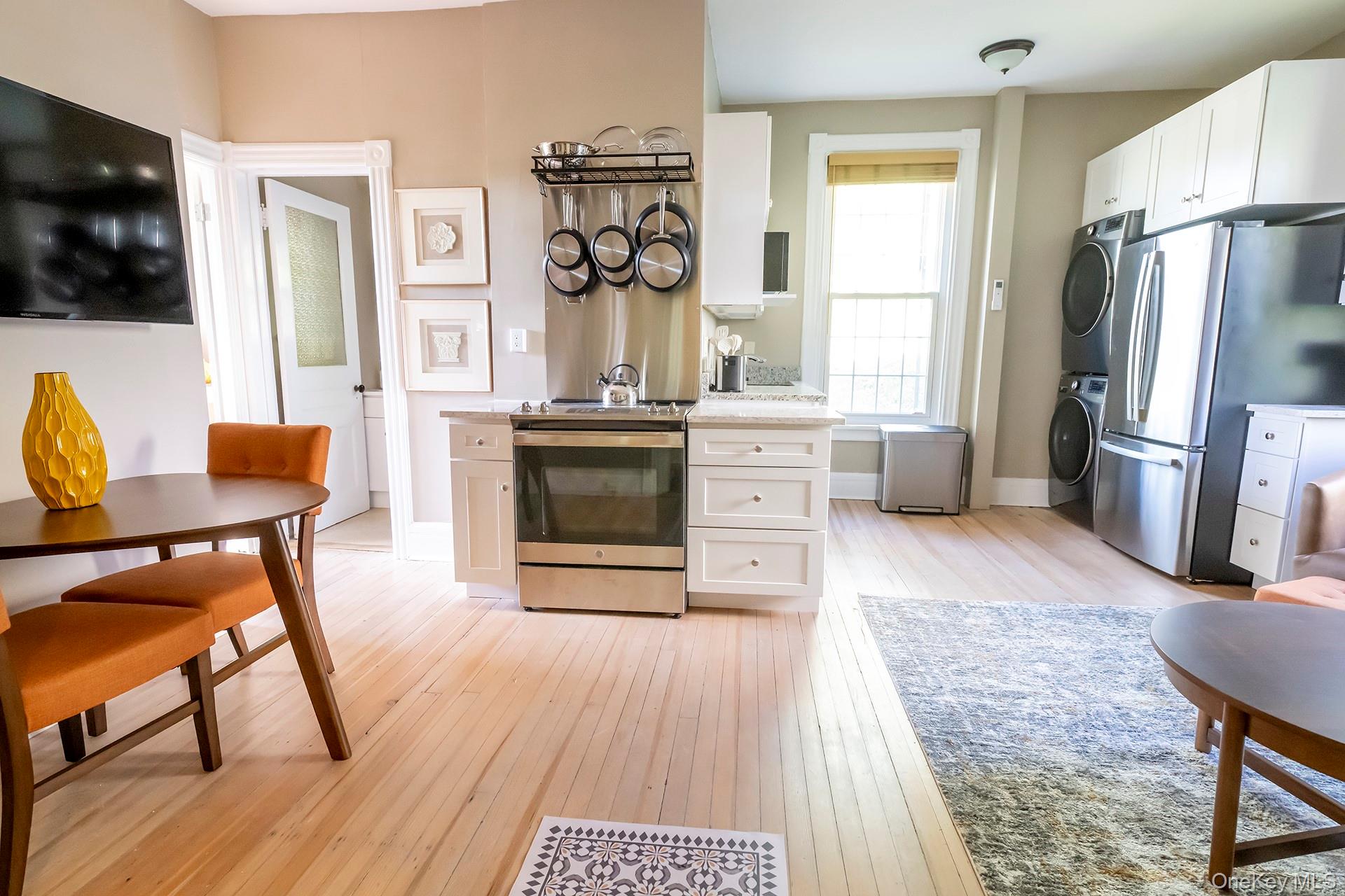 3212 Franklin Avenue, Unit 1ST FLOOR NORHT Millbrook, NY 12545 - Photo 10 of 11 a living room with stainless steel appliances furniture a fireplace and a flat screen tv