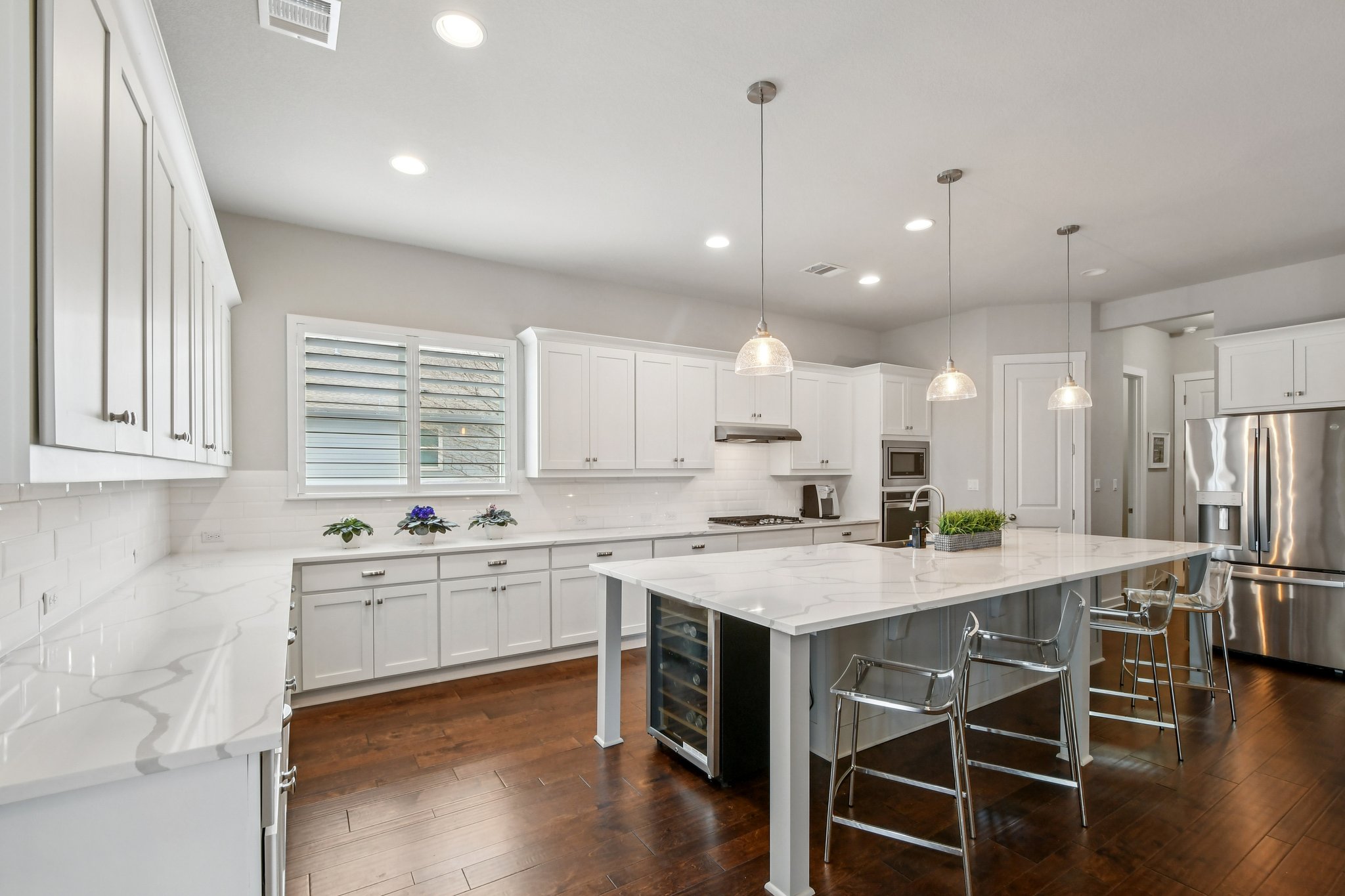 520 Hazy Hills Loop Dripping Springs, TX 78620 - Photo 11 of 27 Gather around the oversized island, perfect for meal prep, casual dining, or hosting guests. The modern kitchen easily transitions into the adjoining dining area, making dinner parties and family meals a breeze.