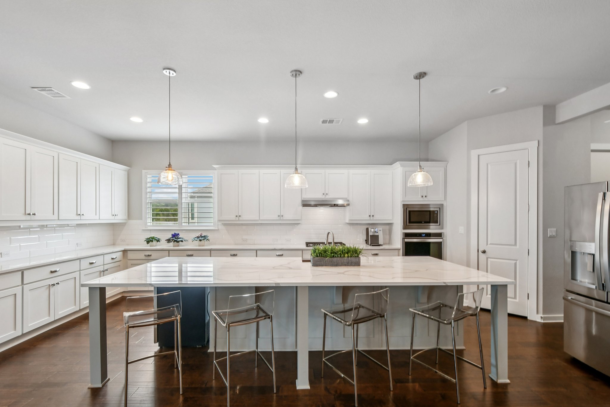 520 Hazy Hills Loop Dripping Springs, TX 78620 - Photo 3 of 27 Gather around the oversized island, perfect for meal prep, casual dining, or hosting guests. The modern kitchen easily transitions into the adjoining dining area, making dinner parties and family meals a breeze.