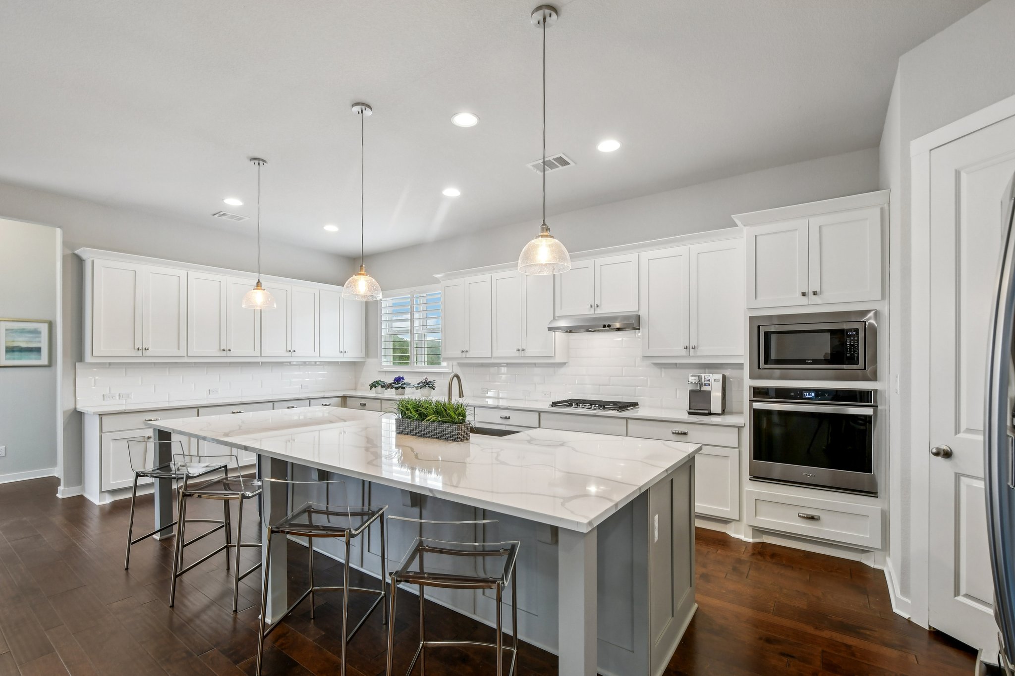 520 Hazy Hills Loop Dripping Springs, TX 78620 - Photo 7 of 27 Gather around the oversized island, perfect for meal prep, casual dining, or hosting guests. The modern kitchen easily transitions into the adjoining dining area, making dinner parties and family meals a breeze.