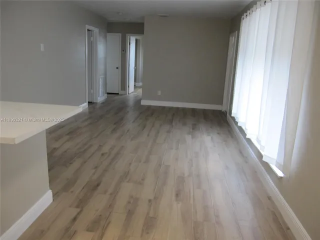 a view of a room with wooden floor and window
