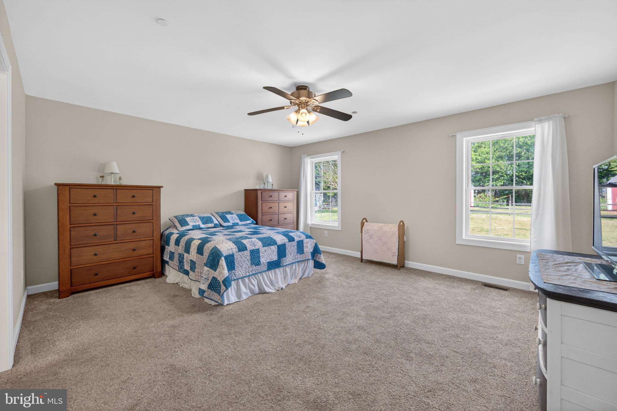 23283 Magnolia Hills Road Denton, MD 21629 - Photo 31 of 54 a bedroom with a bed and a chandelier