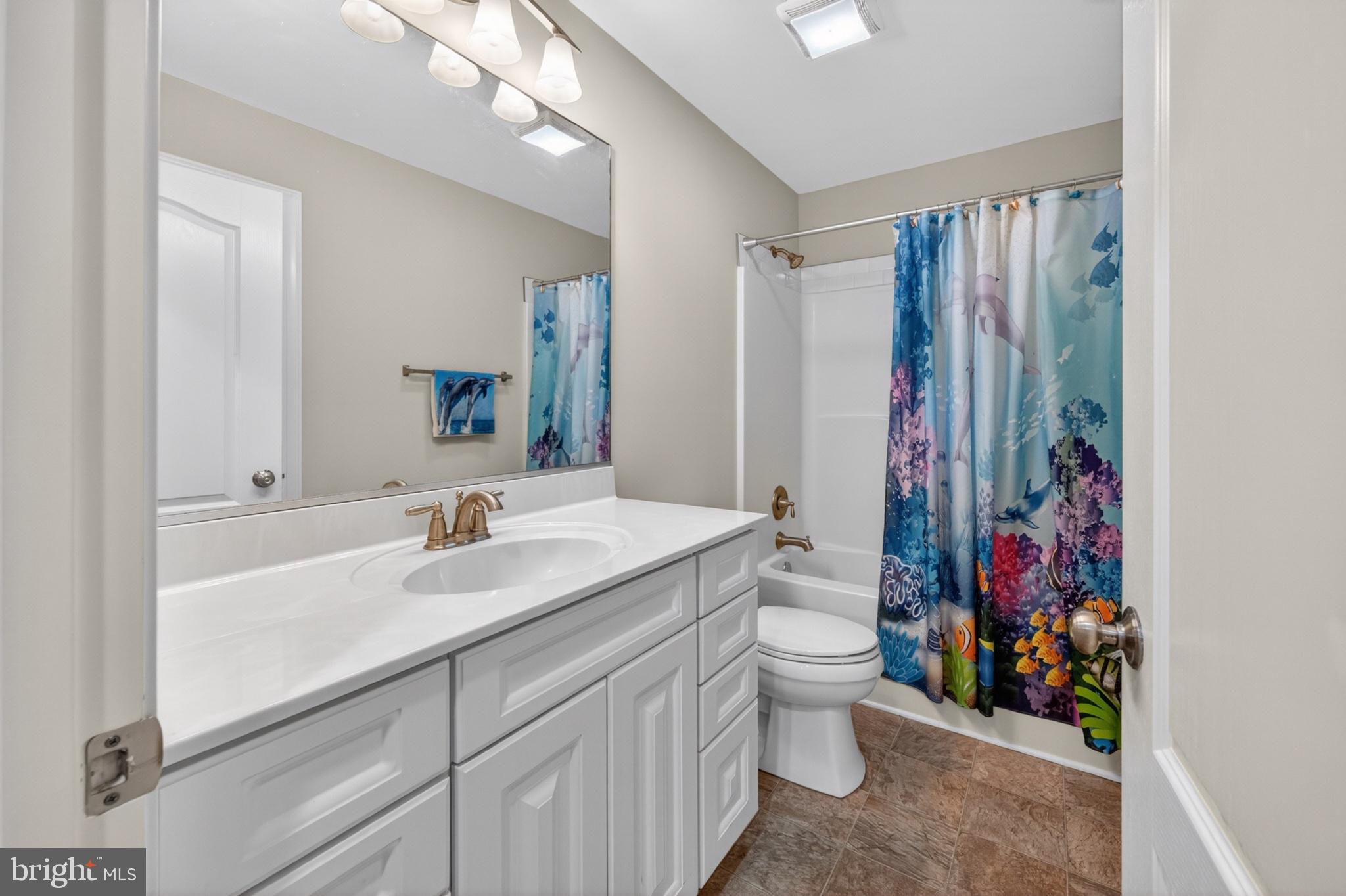 23283 Magnolia Hills Road Denton, MD 21629 - Photo 37 of 54 a bathroom with a sink a toilet and shower curtain