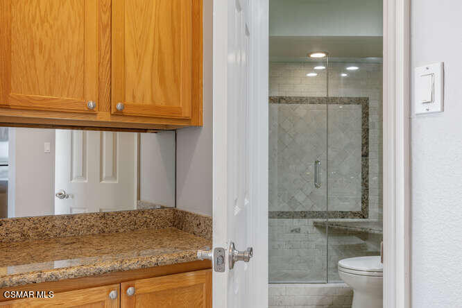 2901 Peninsula Road, Unit 348 Oxnard, CA 93035 - Photo 15 of 22 a bathroom with a granite countertop sink and a mirror